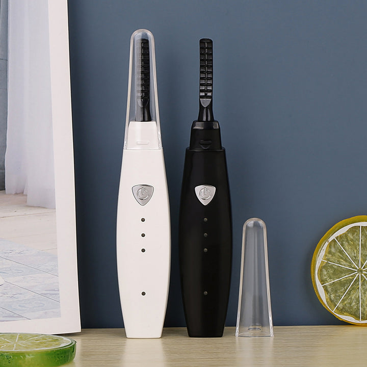 Heated eyelash curler in use on lashes